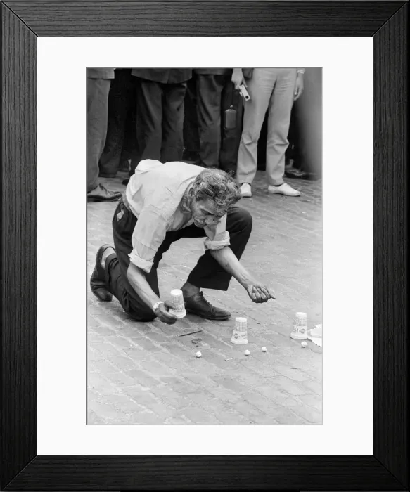 Framed Print : A man entertains crowds on the streets of London with his magic tricks Framed Print : A man entertains crowds on the streets of London with his magic tricks