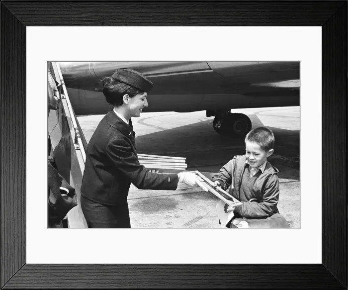 Framed Print : Air hostess with boy at Heathrow airport. 1st June 1965 Framed Print : Air hostess with boy at Heathrow airport. 1st June 1965