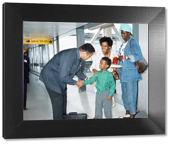 Muhammad Ali at Heathrow Airport shaking a young boys hand. 15th October 1989