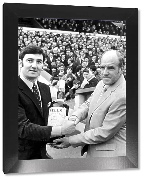 Cardiff City manager Jimmy Scoular receives a gallon bottle of Bells Whisky as manager of