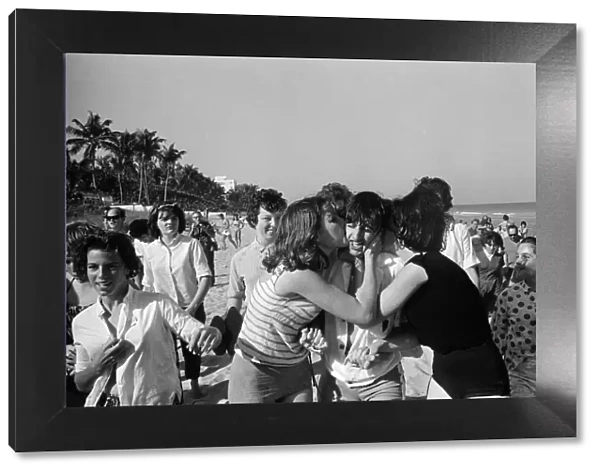 Ringo Starr is besieged by schoolgirls as he strolls on a beach in Miami, Florida