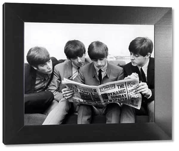 The Beatles, sit down to read the latest issue of The Sunday Mirror Newspaper