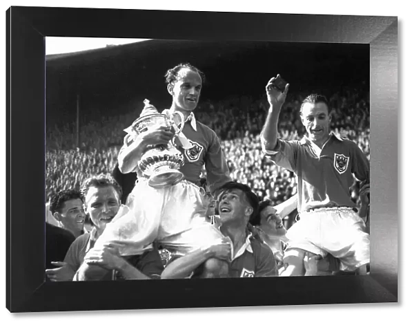 Blackpool footballer Stanley Matthews is carried on the shoulders of his team mates as