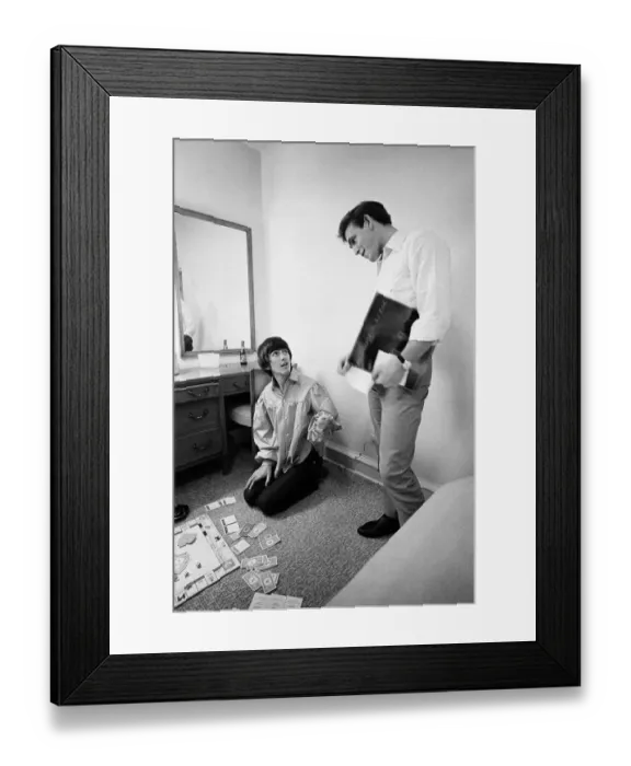 Framed Print : George Harrison speaks with Neil Aspinall while enjoying a game of Monopoly with singer Framed Print : George Harrison speaks with Neil Aspinall while enjoying a game of Monopoly with singer