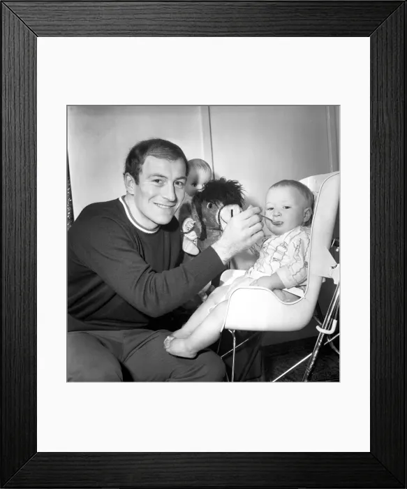 Framed Print : Burnley football player Ralph Coates feeds his new baby girl Lisa. December 1969
