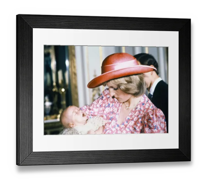 Framed Print : Princess Diana, watched by husband prince Charles, holds her son Prince William in her Framed Print : Princess Diana, watched by husband prince Charles, holds her son Prince William in her