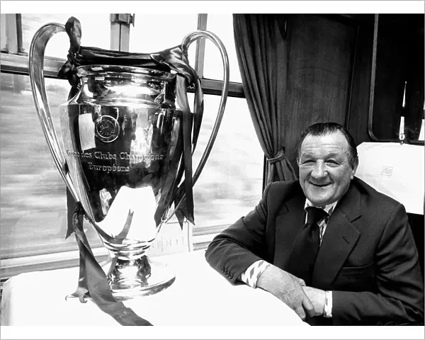 Liverpool manager Bob Paisley withthe European Cup trophy sitting on a train following