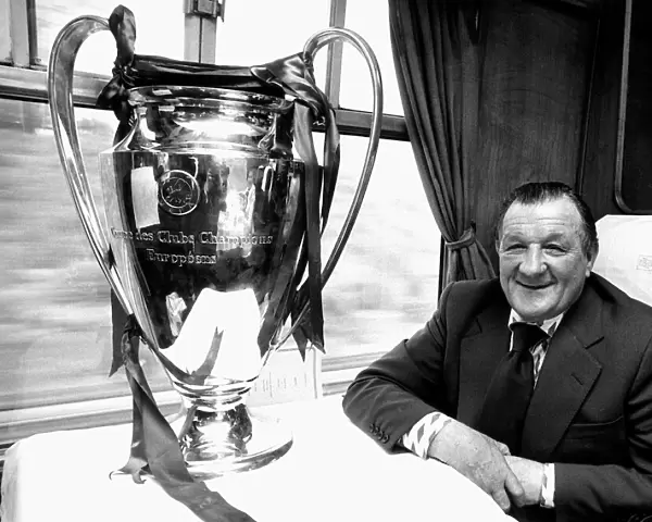 Liverpool manager Bob Paisley withthe European Cup trophy sitting on a train following