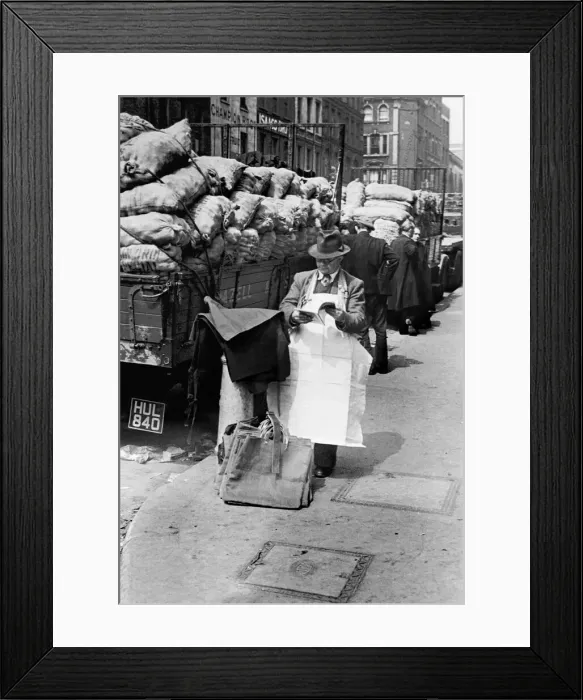 Framed Print : Covent Garden Market stall vendor stops to read a magazine. Circa 1955 Framed Print : Covent Garden Market stall vendor stops to read a magazine. Circa 1955