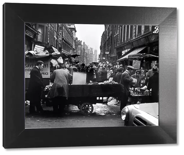 Rupert Street, Soho. Fruit and Veg is sold from a cart outside Boots. Circa 1955