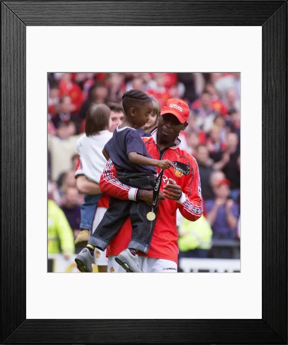 Framed Print : Andy Cole Manchester United footballer May 1999 celebrating carrying his young son Framed Print : Andy Cole Manchester United footballer May 1999 celebrating carrying his young son