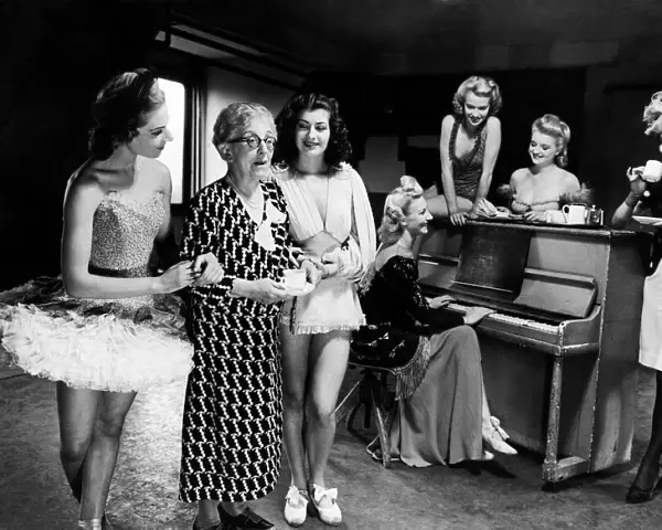 Mrs Laura Henderson owner of the Windmill Theatre seen here taking coffee with some of