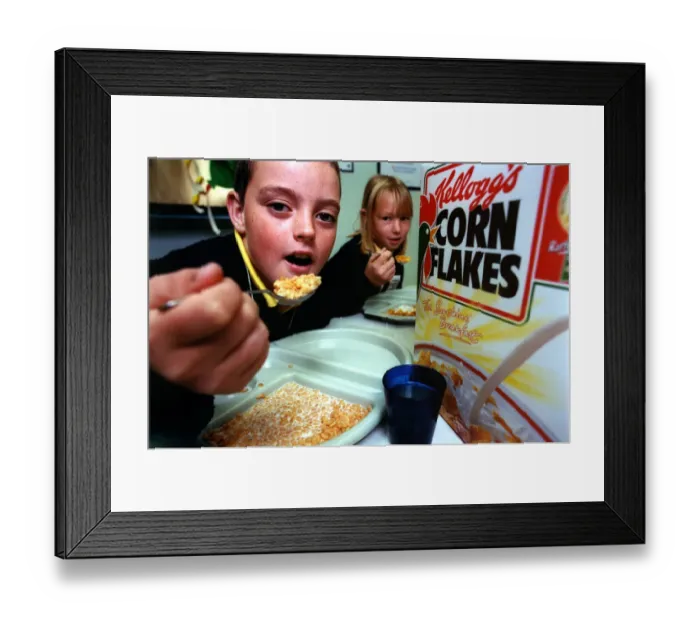 Framed Print : Alan Jackson, 10, and Jenene Brodie, 9, tuck into their breakfast at Laurel Avenue