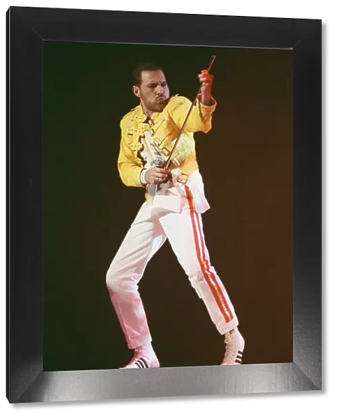 Freddie Mercury, lead singer of rock group Queen, performing on stage