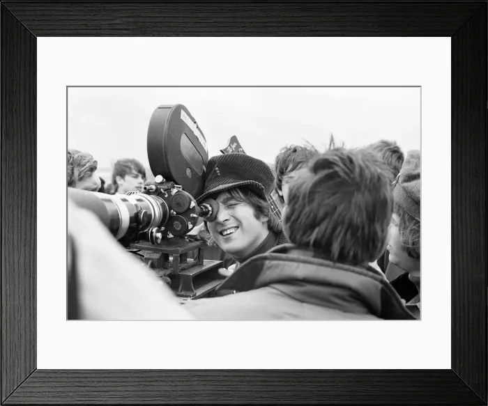 Framed Print : John Lennon of the Beatles pop group, looking through the lens of a camera during Framed Print : John Lennon of the Beatles pop group, looking through the lens of a camera during
