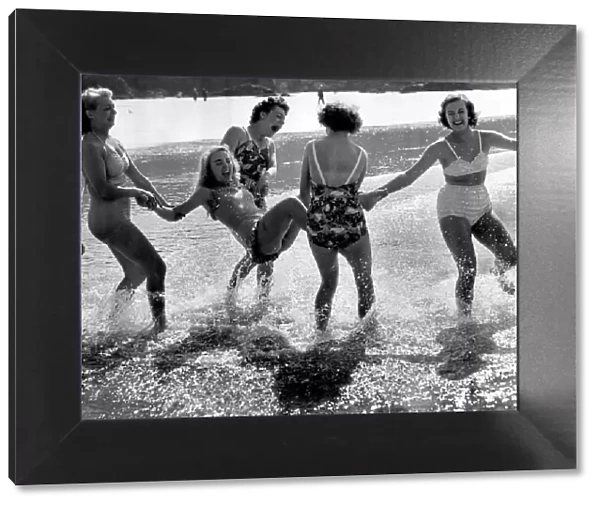 A group of friends playing in the sea at Newquay, Cornwall during the Whitsun bank