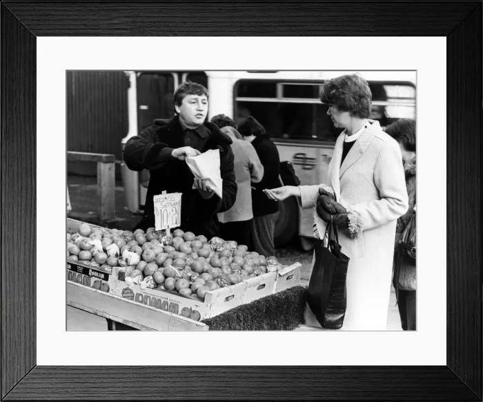Framed Print : Illegal street trader tommy Quinn makes a sale before having to move on 31st January 1981 Framed Print : Illegal street trader tommy Quinn makes a sale before having to move on 31st January 1981