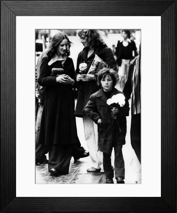 Framed Print : A child selling paper flowers on the streets of Newcastle on 27th December 1974 Framed Print : A child selling paper flowers on the streets of Newcastle on 27th December 1974