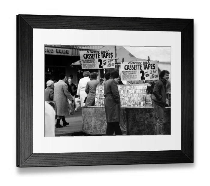 Framed Print : A street trader selling counterfeit cassette tapes from a stall in the Bigg Marker
