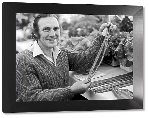 A man holding a selection of runner beans which are in a competition at Egton