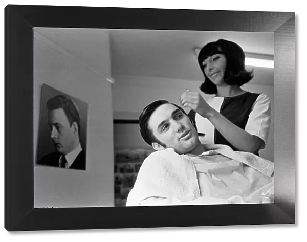Manchester United footballer George Best has his hair cut by Lynda Cole