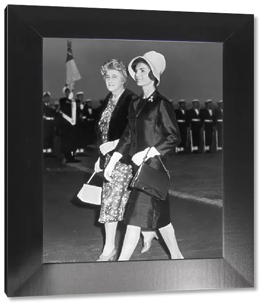 Jacqueline Onassis Kennedy walking across the tarmac with Mrs Dorothy MacMillan having