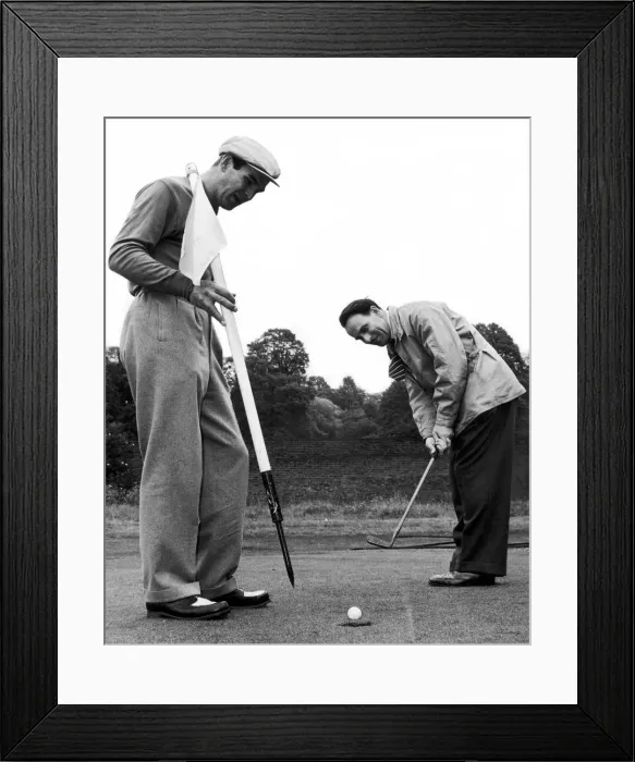 Framed Print : Birmingham Mail film critic Arthur Steele plays golf with Stanley Baker in Richmond