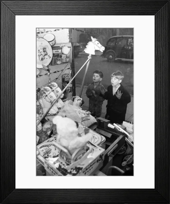 Framed Print : Children look longingly at toys into shop window at Christmas, 16th December 1960