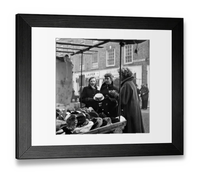 Framed Print : Women out looking for a bargain on the milliner stall at Petticoat Lane Market Framed Print : Women out looking for a bargain on the milliner stall at Petticoat Lane Market