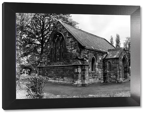 The Chapel among the trees at Eston cemetery, one of the panes in the leaded windows is