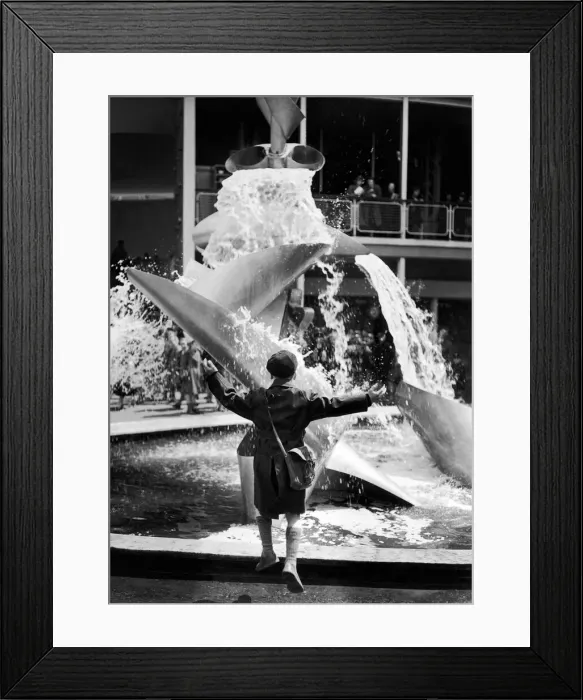 Framed Print : A young boy jumps for joy whilst looking at a modern water feature at the Festival of Framed Print : A young boy jumps for joy whilst looking at a modern water feature at the Festival of