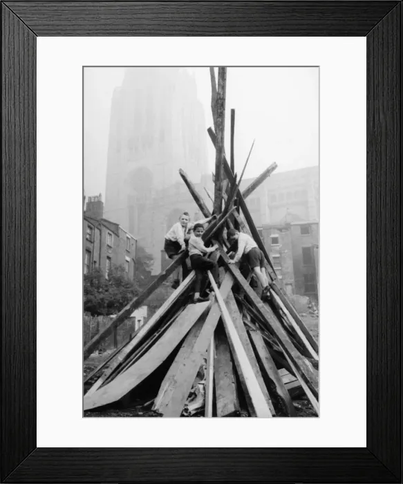 Framed Print : A group of schoolboys seen here adding the final touches to their bonfire in the shadow Framed Print : A group of schoolboys seen here adding the final touches to their bonfire in the shadow