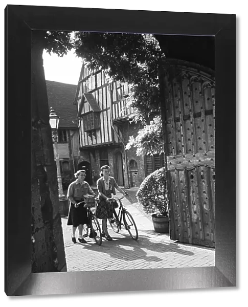 Two women pushing their bicycles through Cheyneys Court in Winchester, Circa 1945