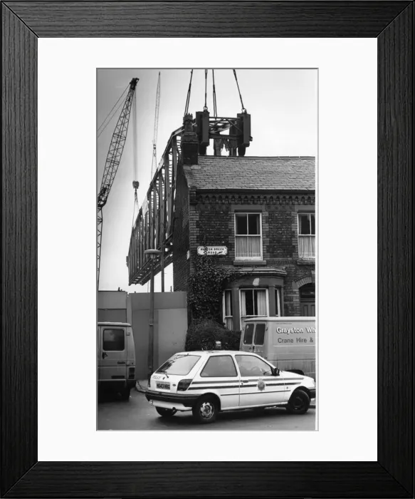Framed Print : The main supporting girder for the new Kemlyn Road Stand is hoisted into place seen here Framed Print : The main supporting girder for the new Kemlyn Road Stand is hoisted into place seen here