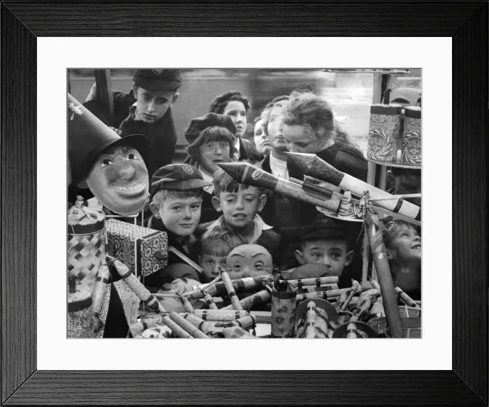 Framed Print : A jumble of small faces peer at a pile of very big bangers