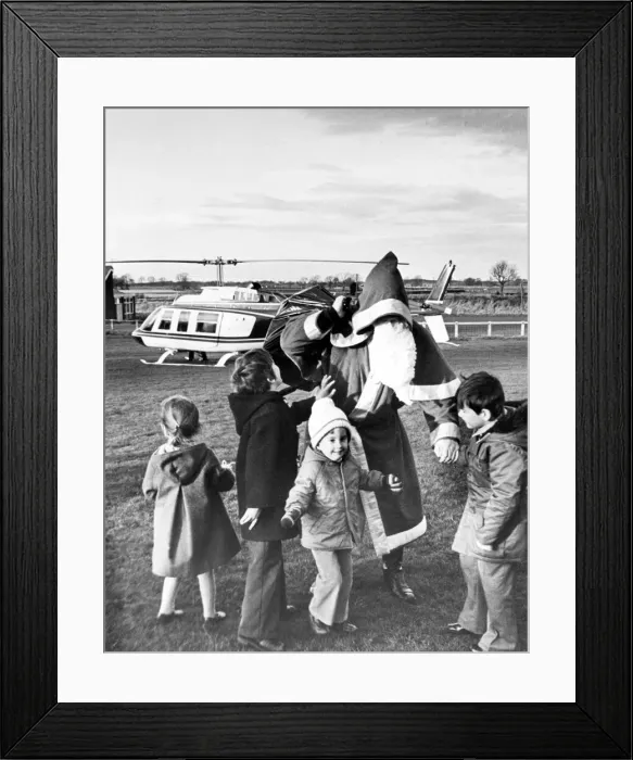 Framed Print : Father Christmas visits a group of very excited children by helicopter, Teesside Framed Print : Father Christmas visits a group of very excited children by helicopter, Teesside
