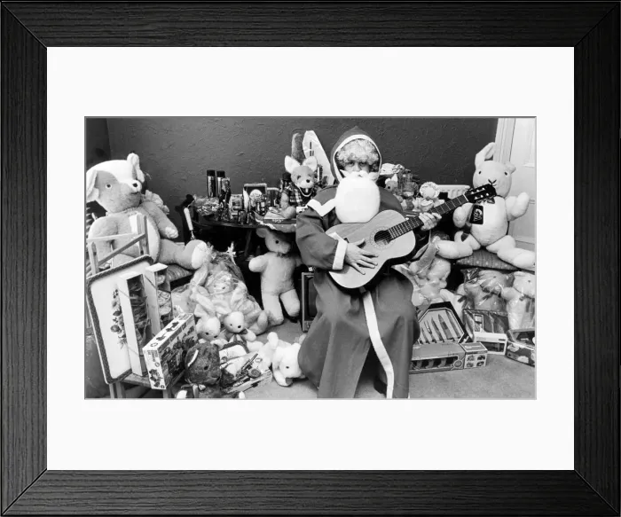 Framed Print : Rod Johnson, a guitar playing Father Christmas, surrounded by toys Framed Print : Rod Johnson, a guitar playing Father Christmas, surrounded by toys