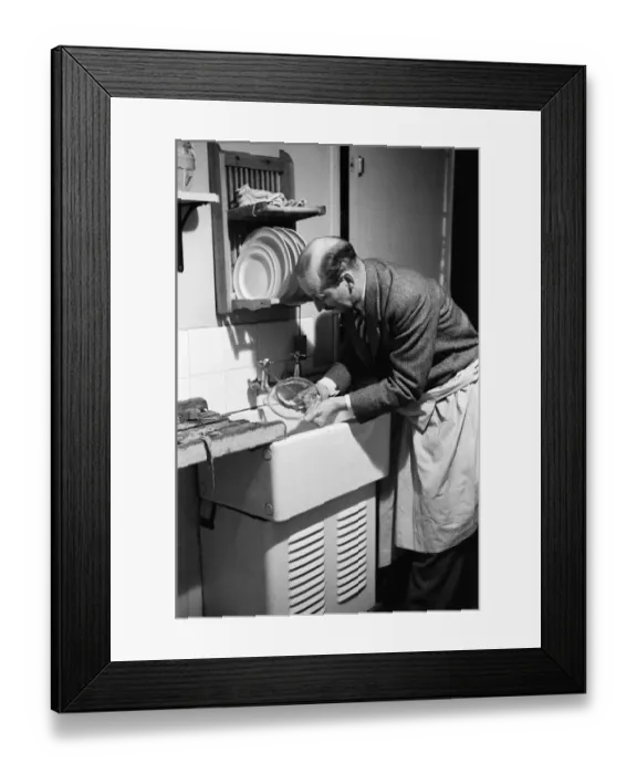 Framed Print : Ted Castle, the husband of Barbara Castle, doing the washing up at the kitchen sink