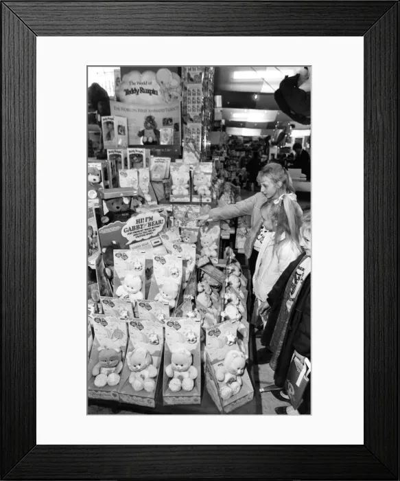 Framed Print : Christmas Shopping Trip, 25th November 1986. Young girls examine Gabby Bear Dolls Framed Print : Christmas Shopping Trip, 25th November 1986. Young girls examine Gabby Bear Dolls