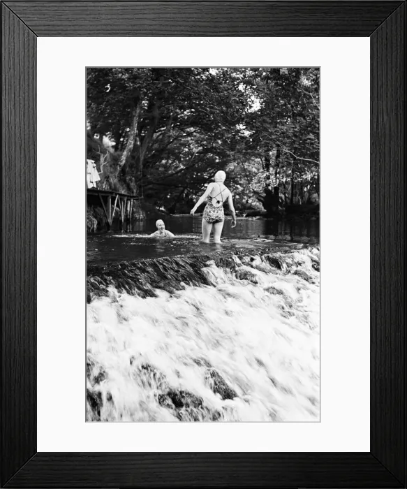 Framed Print : Two women having fun at the top of a waterfall, while on a holiday with Framed Print : Two women having fun at the top of a waterfall, while on a holiday with