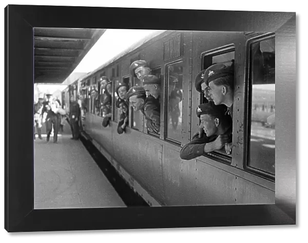 Sailors lean out of a train window as they depart for their ship. June 1947
