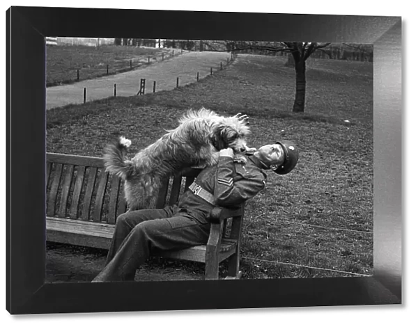 One of the Queens Guardsmen in a park with a dog, London, circa February 1948