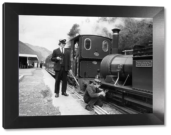 A woker applying some oil to one of the steam trains on the Talyllyn railway line which