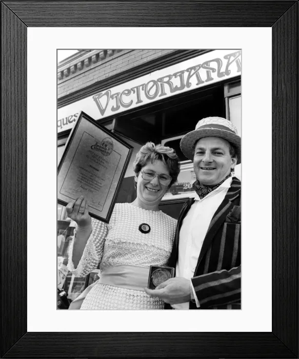 Framed Print : Trevor and Joan Taylor pose with their award for their window display at their shop Framed Print : Trevor and Joan Taylor pose with their award for their window display at their shop