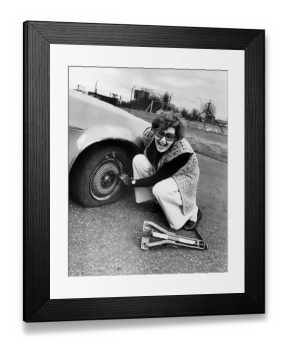 Framed Print : Birmingham Mail fashion editor Barbara Henderson has a go at changing a flat tyre