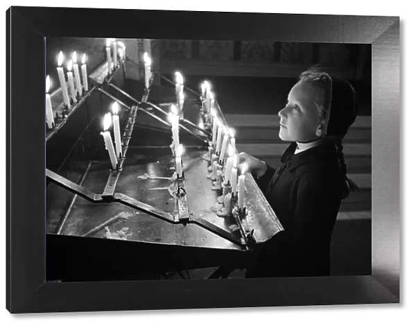 A young girl looking at candles at Westminster Cathedral, London, October 1946