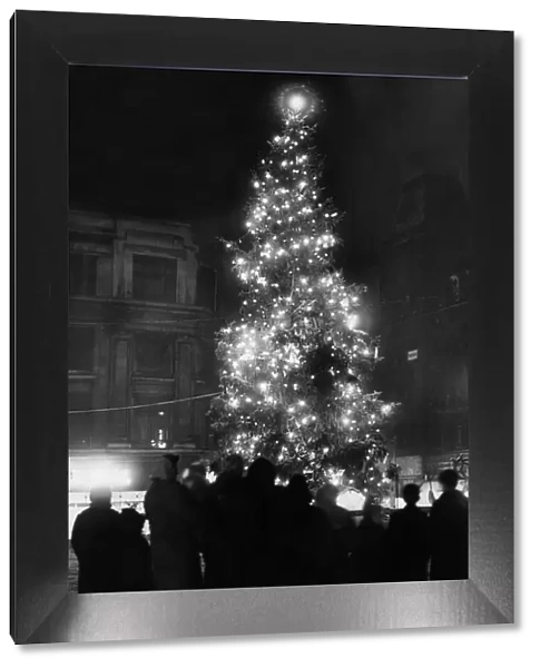 A family group admire the lit Christmas Tree in Church Street after a fresh fall of snow