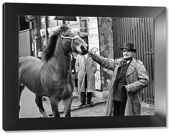A man with a horse, standing outside the site of a cart and van horse auction