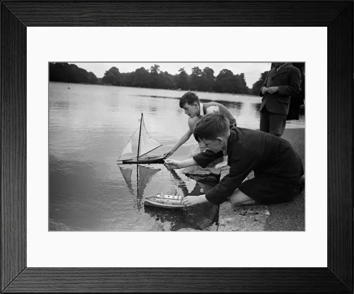 Framed Print : Children sailing their toy yachts on the Round Pond in Kensington Gardens, London Framed Print : Children sailing their toy yachts on the Round Pond in Kensington Gardens, London