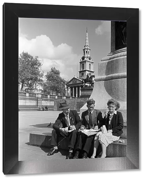 Three adults eating their packed lunch in Trafalgar Square, Westminster, London